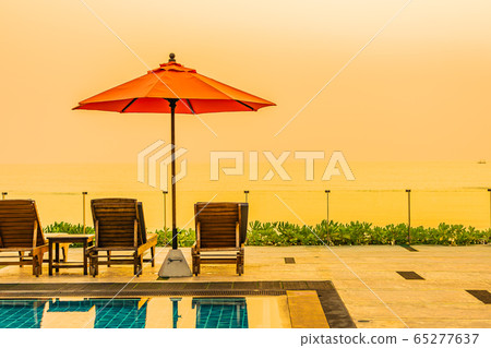 Beautiful sunrise around with umbrella and chair outdoor swimming pool Beautiful sunrise around with umbrella and chair outdoor swimming pool 65277637