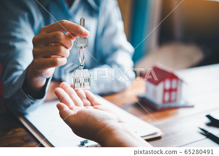 real estate agent gives the keys to the house 65280491