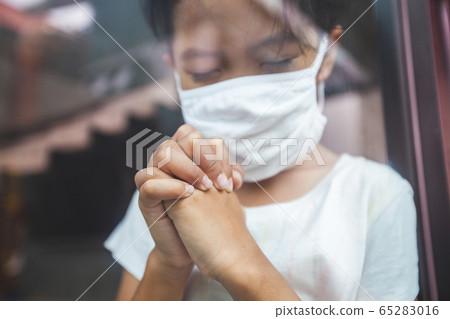 Asian child girl wearing protection mask praying for a new day freedom to coronavirus Covid-19 65283016