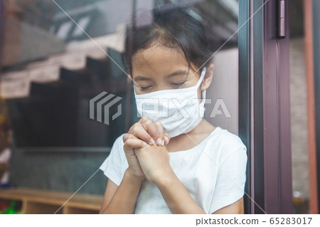 Asian child girl wearing protection mask praying for a new day freedom to coronavirus Covid-19 65283017
