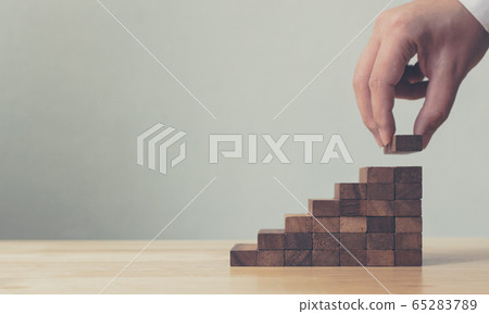 Hand arranging wood block stacking as step stair Hand arranging wood block stacking as step stair 65283789