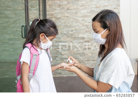 Asian mother and child girl wearing protection mask using disinfectant gel wash hand Asian mother and child girl wearing protection mask using disinfectant gel wash hand 65283857
