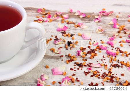 Cup of tea with dried wild rose flower 65284014