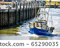 A small fishing boat enters the harbour of Busum in North Frisia in Germany. 65290035