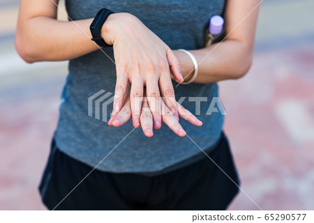 Woman using hand sanitizer for disinfection 65290577