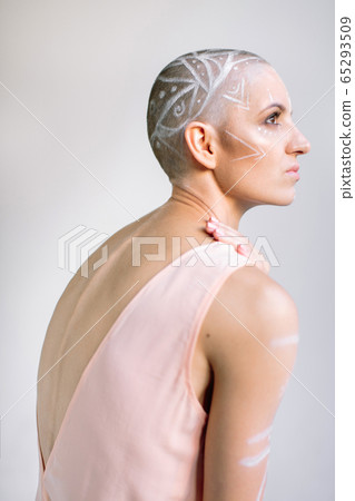 Sensual woman with painted head against gray 65293509