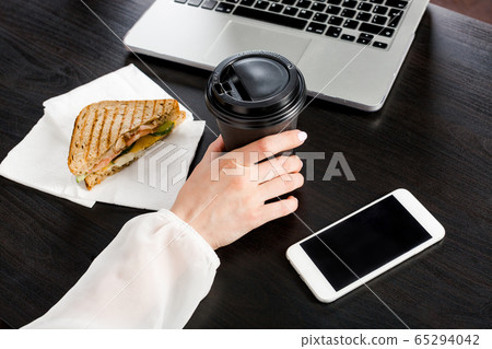 a woman's hand in a white blouse holds a a woman's hand in a white blouse holds a 65294042