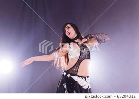 Spirituality dance. Beautiful sexy woman with luxury glossy eastern make-up dancing tribal fusion. Belly dance. Spirituality dance. Beautiful sexy woman with luxury glossy eastern make-up dancing tribal fusion. Belly dance. 65294312