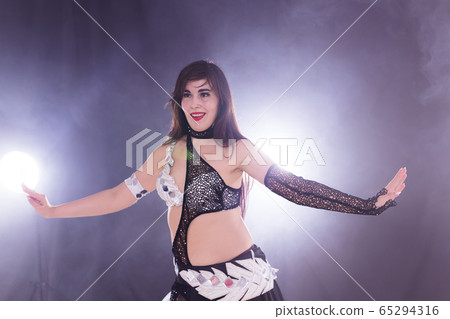 Young woman dancing in Tribal Fusion style. Belly dance on the stage. Young woman dancing in Tribal Fusion style. Belly dance on the stage. 65294316