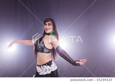 Spirituality dance. Beautiful sexy woman with luxury glossy eastern make-up dancing tribal fusion. Belly dance. Spirituality dance. Beautiful sexy woman with luxury glossy eastern make-up dancing tribal fusion. Belly dance. 65294323
