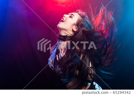 Young woman belly dancer in exotic dress with gold, dancing tribal fusion dance in studio. Young woman belly dancer in exotic dress with gold, dancing tribal fusion dance in studio. 65294342