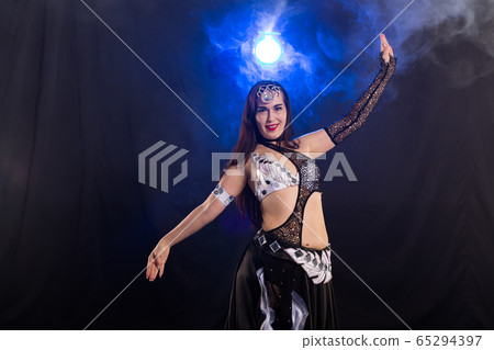 Young woman dancing in Tribal Fusion style. Belly dance on the stage. Young woman dancing in Tribal Fusion style. Belly dance on the stage. 65294397
