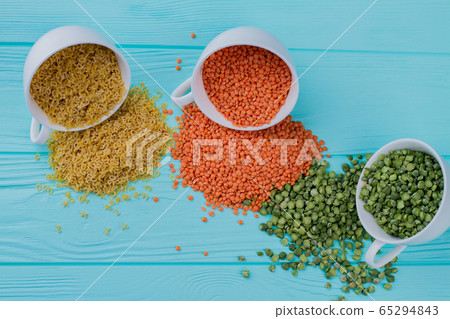 Three different types of cereals spilled out of cups. Three different types of cereals spilled out of cups. 65294843