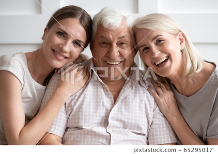 Portrait of senior parents posing with adult daughter 65295017