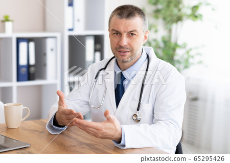 Portrait of mature doctor talking at camera Portrait of mature doctor talking at camera 65295426