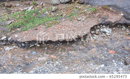 Water erosion of the road. Broken asphalt Water erosion of the road. Broken asphalt 65295473