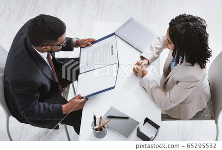 Above view of HR manager with resume and vacancy applicant on job interview in office. Blank space Above view of HR manager with resume and vacancy applicant on job interview in office. Blank space 65295532