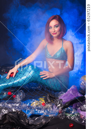 Ocean plastic pollution concept. Mermaid scared due to polluted habitat. Ocean plastic pollution concept. Mermaid scared due to polluted habitat. 65297219