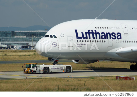 FRANKFURT, GERMANY - JUN 09th, 2017: Airbus A380 of Lufthansa with registration D-AIMH moves on taxiway by tow truck before departure from FRA airport FRANKFURT, GERMANY - JUN 09th, 2017: Airbus A380 of Lufthansa with registration D-AIMH moves on taxiway by tow truck before departure from FRA airport 65297966