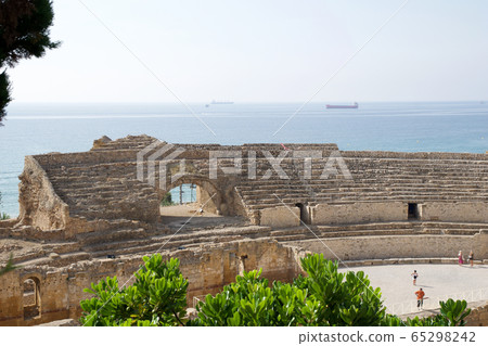 TARRAGONA, SPAIN - AUG 28th, 2017: a panoramic view of the ancient roman amphitheater next to the Mediterranean sea TARRAGONA, SPAIN - AUG 28th, 2017: a panoramic view of the ancient roman amphitheater next to the Mediterranean sea 65298242