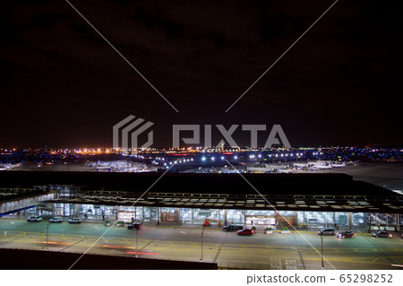 CHICAGO, ILLINOIS, UNITED STATES - MAY 11th, 2018: Outside of Chicago O'Hare International Airport at night with some cars and airplanes at the terminal CHICAGO, ILLINOIS, UNITED STATES - MAY 11th, 2018: Outside of Chicago O'Hare International Airport at night with some cars and airplanes at the terminal 65298252