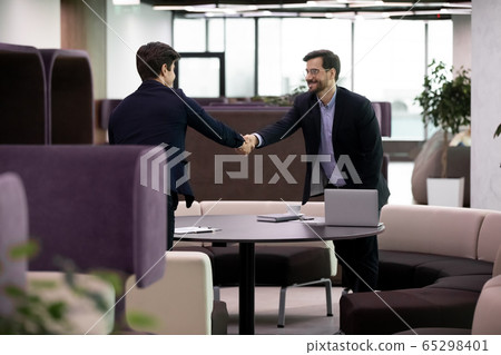Two businessmen at meeting shake hands express respect 65298401