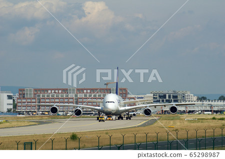 FRANKFURT, GERMANY - JUN 09th, 2017: Airbus A380 of Lufthansa with registration D-AIMH moves on taxiway by tow truck before departure from FRA airport FRANKFURT, GERMANY - JUN 09th, 2017: Airbus A380 of Lufthansa with registration D-AIMH moves on taxiway by tow truck before departure from FRA airport 65298987