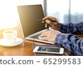 businessman working with modern workplace with laptop on wood table, Man hand on laptop keyboard for work from home 65299583