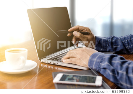 businessman working with modern workplace with laptop on wood table, Man hand on laptop keyboard for work from home 65299583