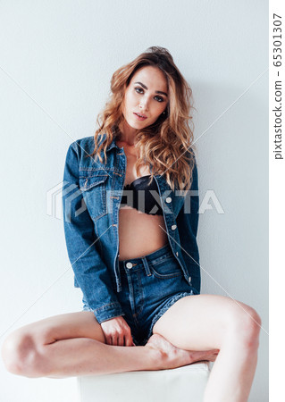 portrait of a beautiful fashionable woman in a denim jacket and shorts portrait of a beautiful fashionable woman in a denim jacket and shorts 65301307