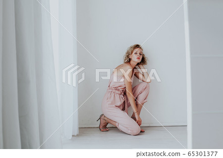 Portrait of a beautiful woman blonde in a fashionable jumpsuit Portrait of a beautiful woman blonde in a fashionable jumpsuit 65301377