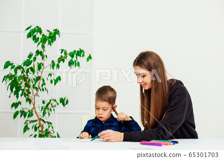mother and young son draws a picture at the table mother and young son draws a picture at the table 65301703