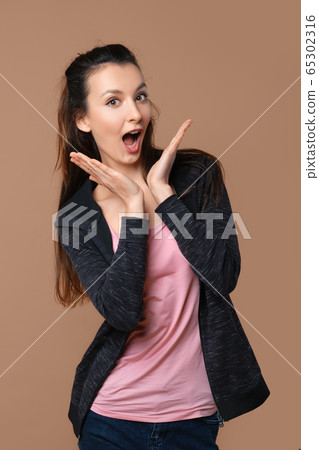 Playful girl making duckface isolated on beige background Playful girl making duckface isolated on beige background 65302316