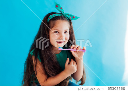 little girl brushing his teeth with a toothbrush dent little girl brushing his teeth with a toothbrush dent 65302368