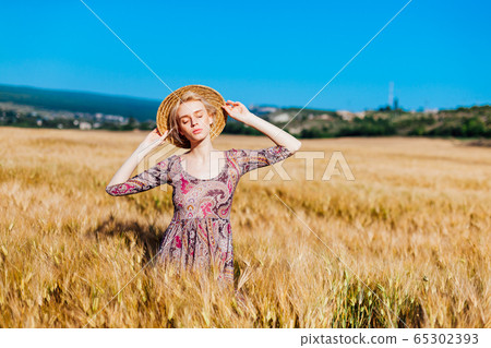 a woman farmer in field of wheat before the harvest 65302393