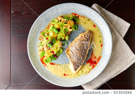 Grilled sea bass fillet with vegetable garnish 65303898