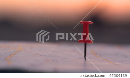 Close up red pin push map under sunset background. Close up red pin push map under sunset background. 65304189