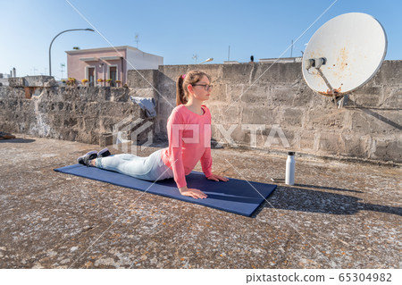 Young girl is doing Upward-Facing Dog pose, Urdhva Young girl is doing Upward-Facing Dog pose, Urdhva 65304982