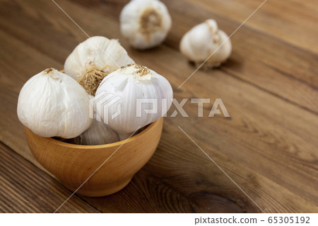 Isolated garlic whole on wooden background. Cooking ingredient. Copy space. Isolated garlic whole on wooden background. Cooking ingredient. Copy space. 65305192