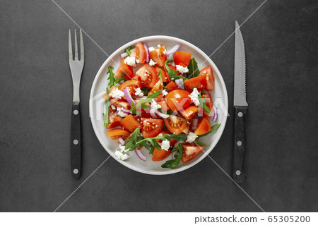 Tomato salad with arugula. Fresh summer foods. Healthy food, vegetarian low calories salad. 65305200