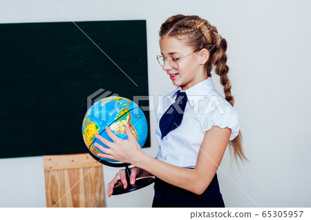 girl with a globe at the Blackboard in a class lesson girl with a globe at the Blackboard in a class lesson 65305957