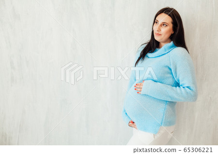 Portrait of a pregnant woman in the blue dress grey walls Portrait of a pregnant woman in the blue dress grey walls 65306221