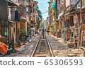 Woman is making a picture of Hanoi city railway Perspective view running along narrow street with houses in Vietnam 65306593