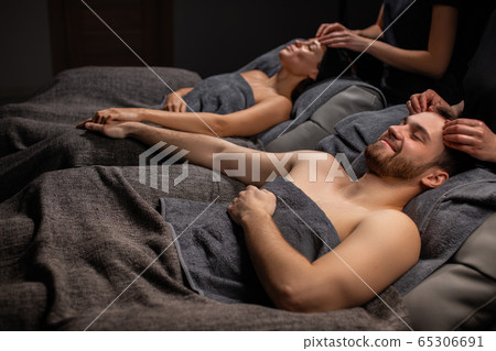 married couple in spa salon getting face treatment married couple in spa salon getting face treatment 65306691