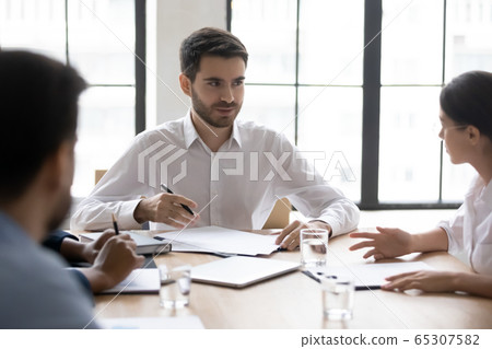 Serious businessman talking with young woman employee about project. Serious businessman talking with young woman employee about project. 65307582