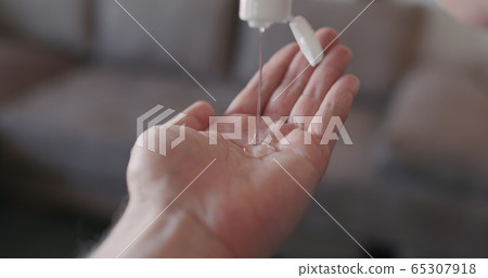 pov shot of man apply sanitizer gel to his hands closeup 65307918