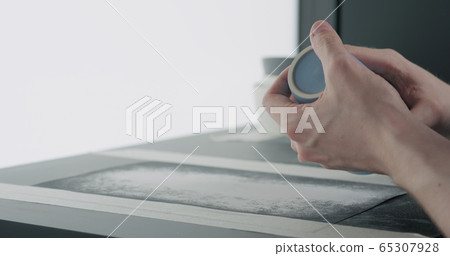 man hands check bottom of blue ceramic glass 65307928