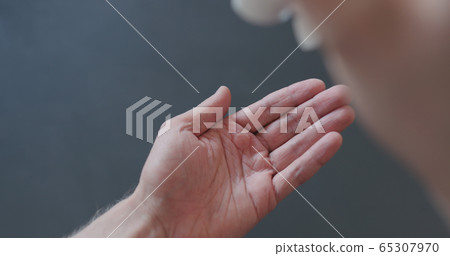 pov shot of man apply sanitizer gel to his hands closeup 65307970