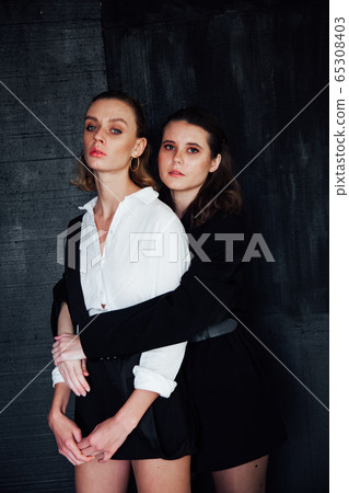 Two beautiful fashionable women stand next to brunette and blonde 65308403