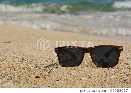 Dark Brown Sunglasses on Beach Sand in Greece 65308617